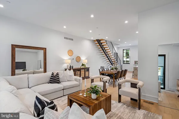 a living room with furniture a flat screen tv and a large window