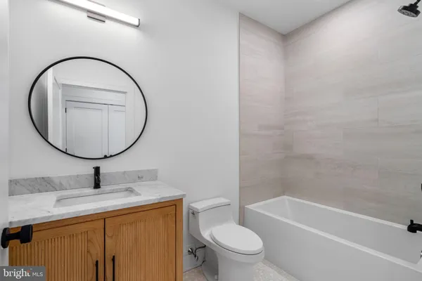 a bathroom with a granite countertop sink mirror and bathtub