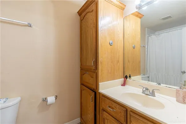 a bathroom with a sink and mirror with toilet