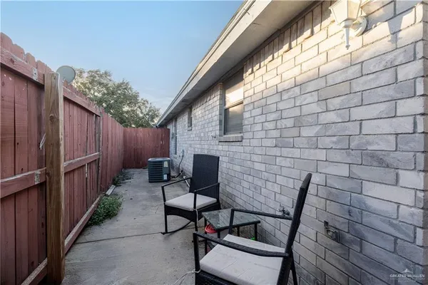 a view of a patio with table and chairs with wooden fence and plants