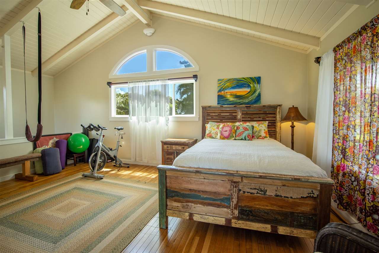 475 Haumana Road Haiku, HI 96708 - Photo 20 of 30 a bedroom with a bed and a chandelier