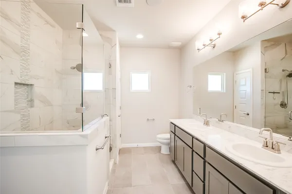 a spacious bathroom with a double vanity sink mirror double and shower