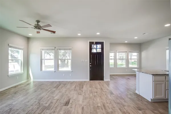 a view of an empty room with a window and wooden floor