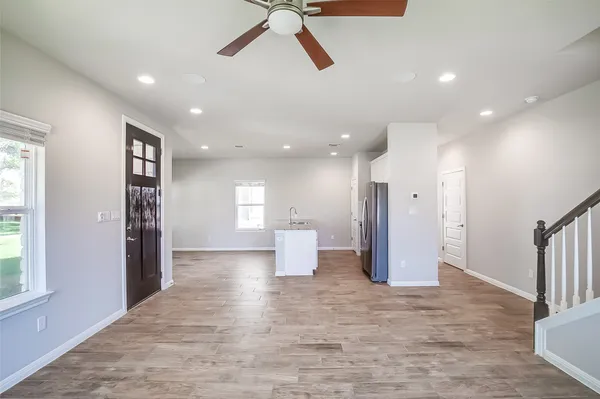 a view of an empty room and a kitchen