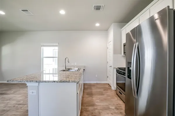 a kitchen with stainless steel appliances granite countertop a refrigerator and a sink