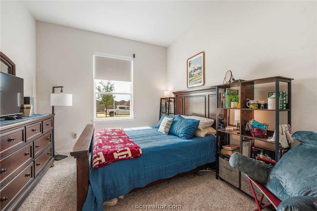 2038 Viva Road Bryan, TX 77807 - Photo 17 of 21 Secondary bedroom with bright natural light and comfortable layout for family or guests with ensuite bathroom attached.