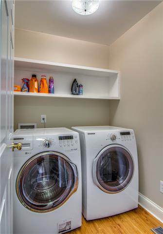2062 Prescott Way Spring Hill, TN 37174 - Photo 15 of 20 This home features a nice utility room with wooden shelves. The seller has installed beautiful wainscoting trim in the hallway and installed designer lighting