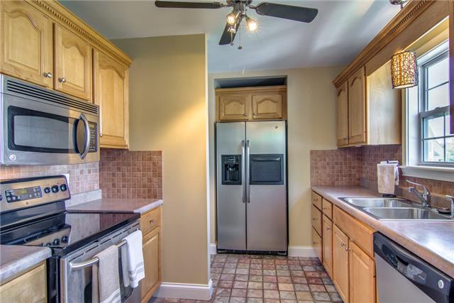 2062 Prescott Way Spring Hill, TN 37174 - Photo 7 of 20 Nice kitchen with stainless steel appliances and tile floor. The refrigerator remains. There is a nice sized pantry with wooden shelves and a door to the garage around the corner.