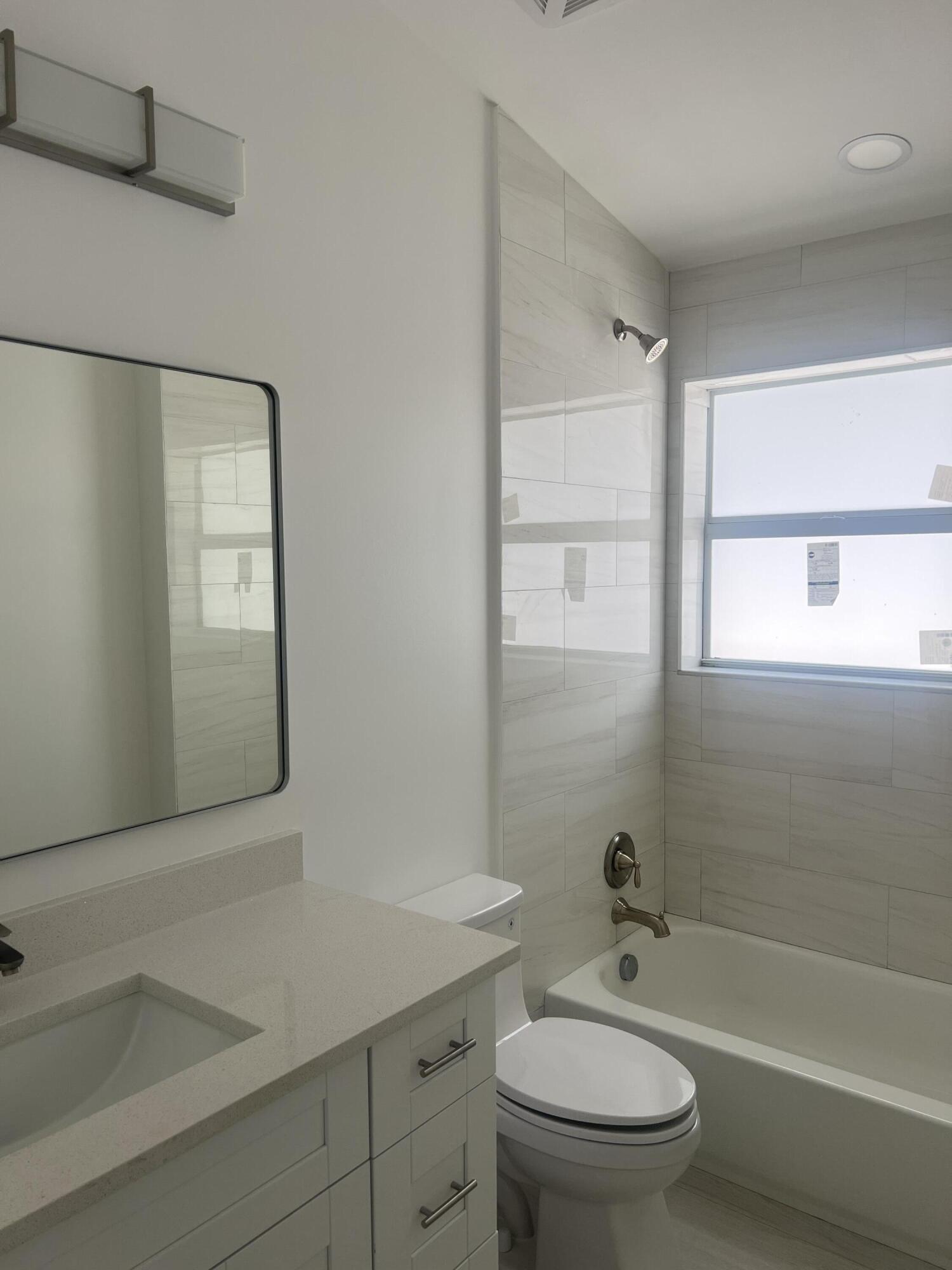 328 Nottingham Boulevard West Palm Beach, FL 33405 - Photo 21 of 22 a bathroom with a granite countertop toilet a sink and a bathtub