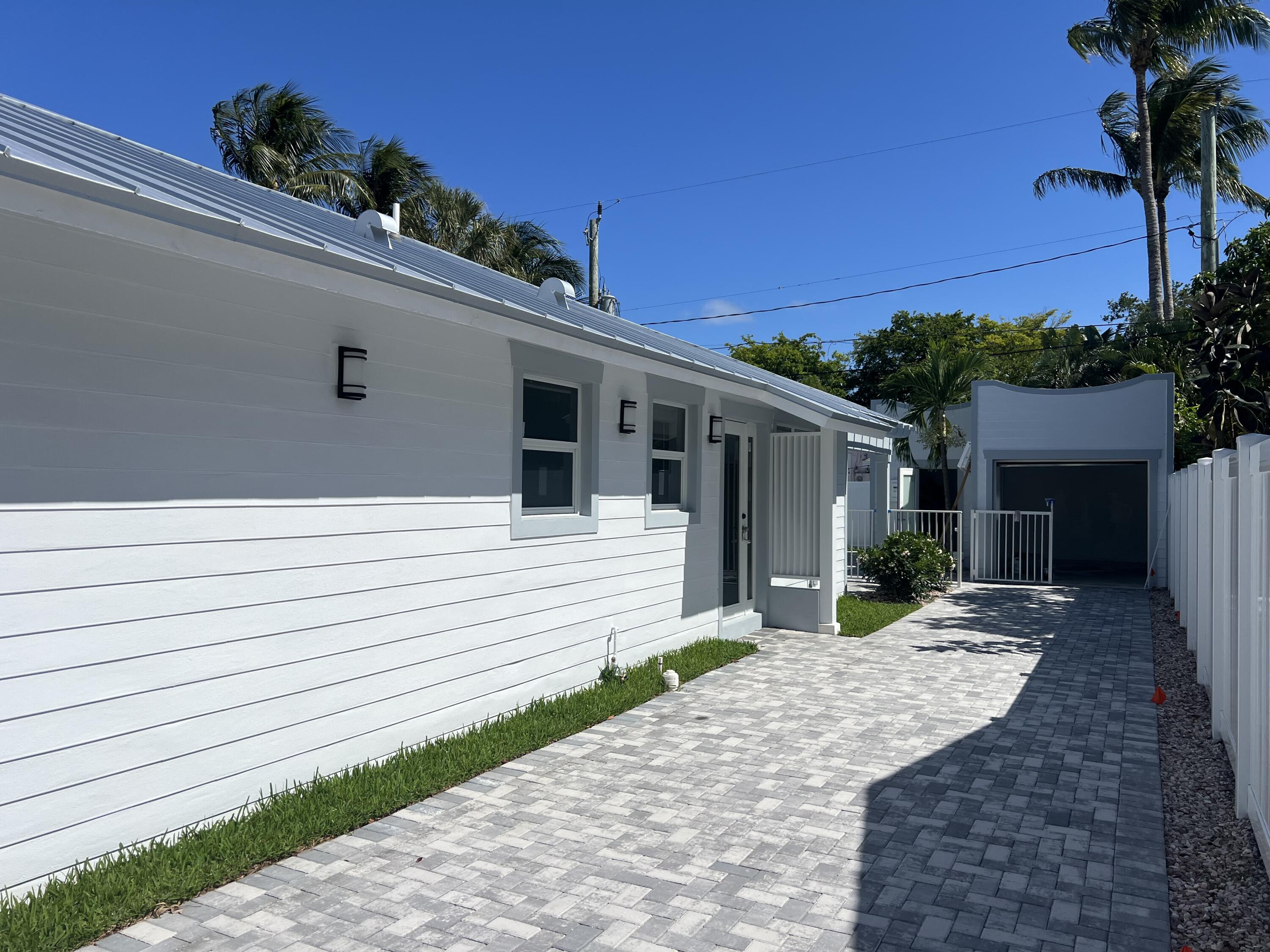 328 Nottingham Boulevard West Palm Beach, FL 33405 - Photo 3 of 22 a front view of a house with a yard and potted plants