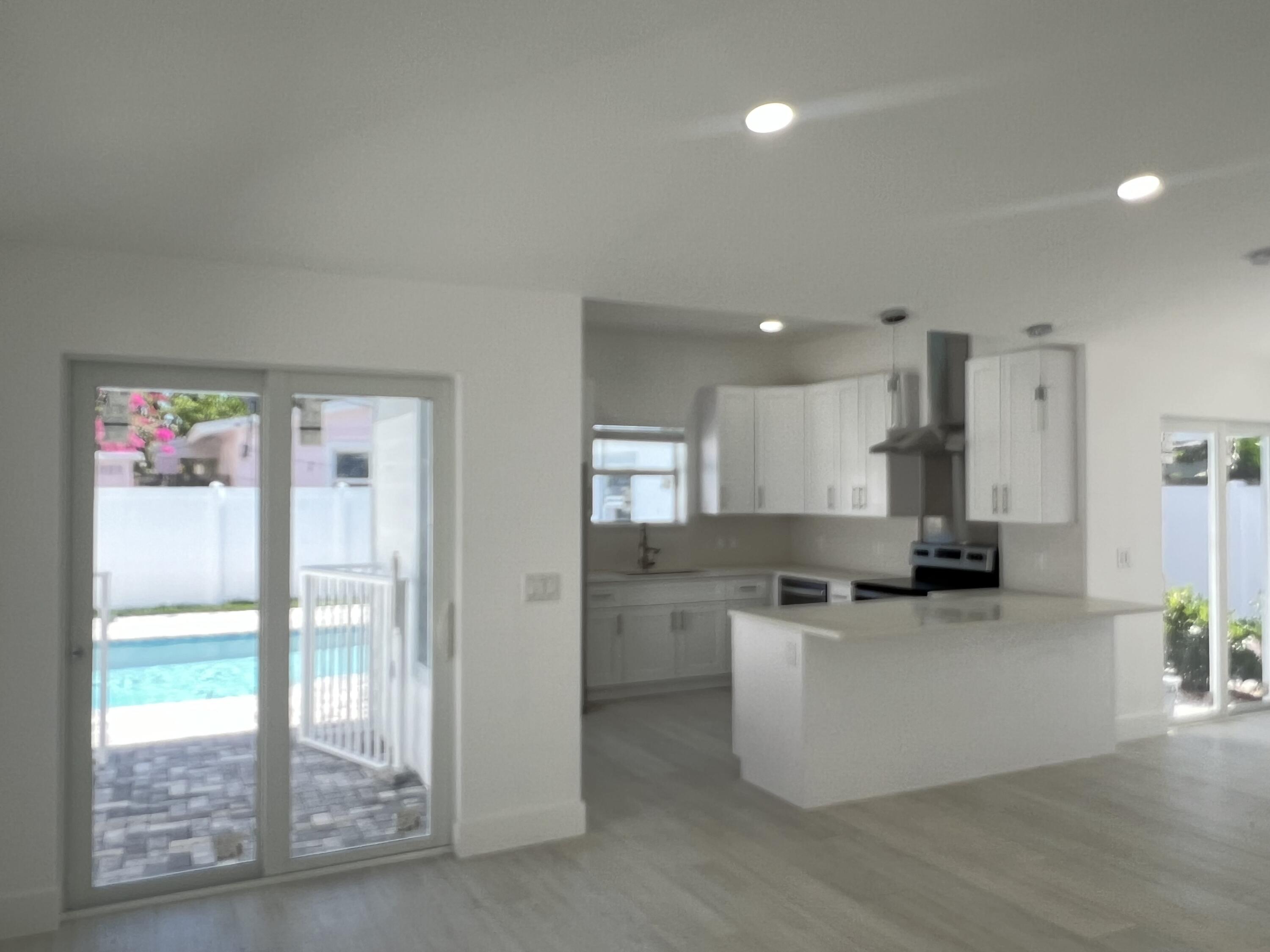 328 Nottingham Boulevard West Palm Beach, FL 33405 - Photo 8 of 22 a kitchen with stainless steel appliances kitchen island granite countertop a refrigerator a sink a stove and white cabinets with wooden floor