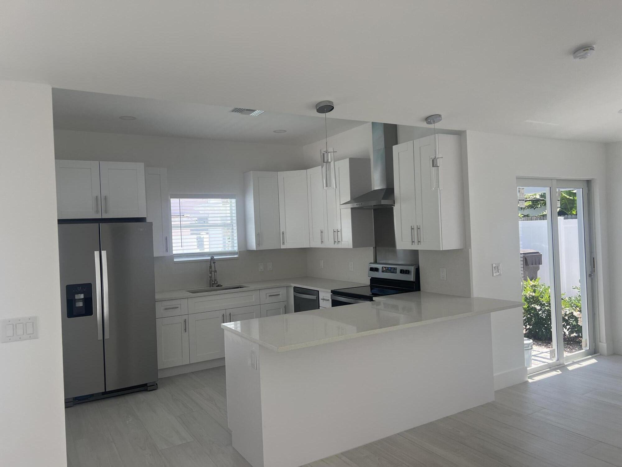 328 Nottingham Boulevard West Palm Beach, FL 33405 - Photo 10 of 22 a kitchen with stainless steel appliances a refrigerator sink and cabinets