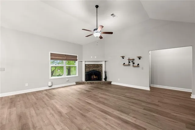 a view of an empty room with a fireplace and a window