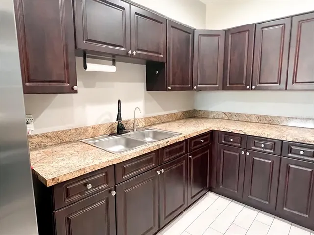 a kitchen with granite countertop a sink and cabinets