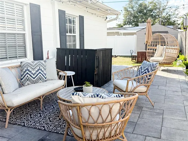 a view of a patio with couches table and chairs and potted plants