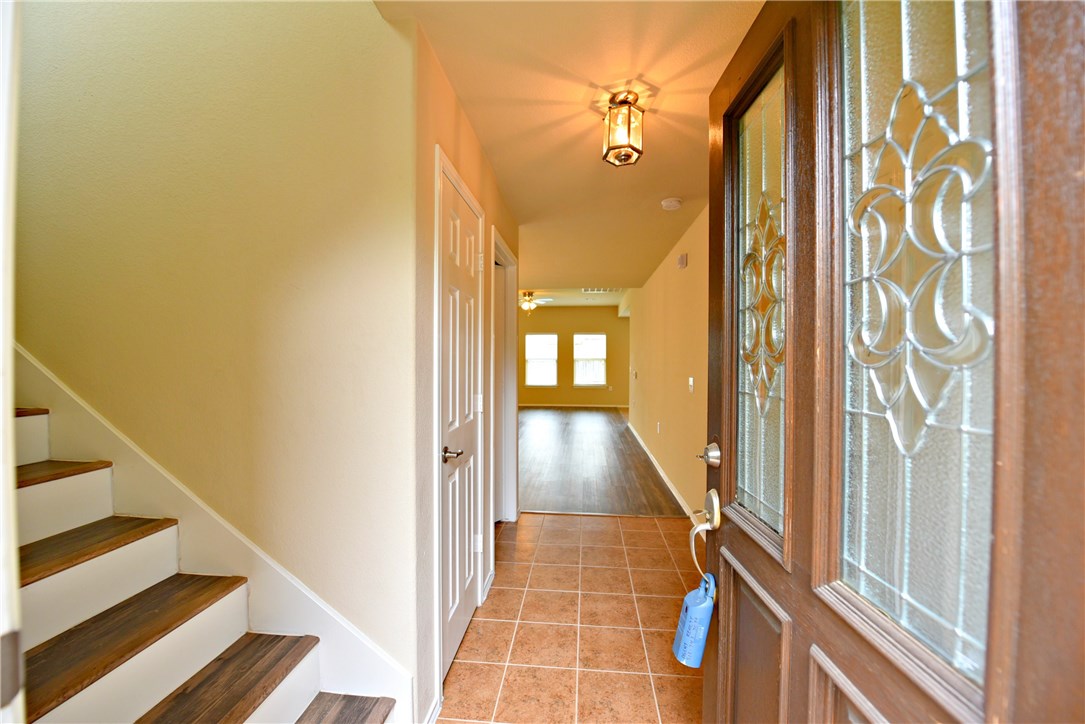a view of a hallway with wooden floor and staircase