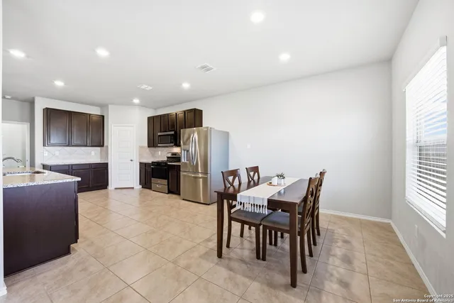 a kitchen with granite countertop a refrigerator and a stove top oven