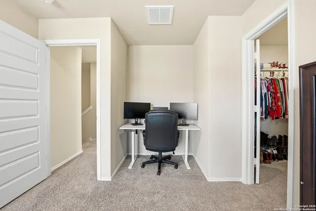 a view of a workspace with furniture and a window