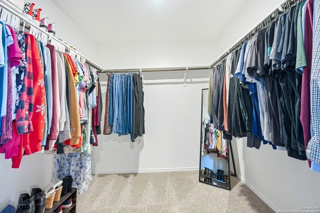 a view of walk in closet with clothes