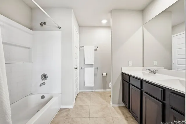 a bathroom with a tub sink shower and mirror