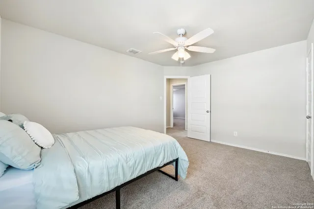 a bedroom with a bed and a chandelier fan