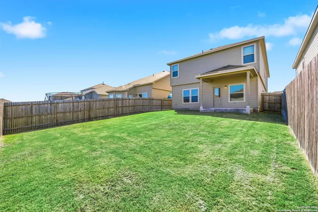 a view of a house with a yard and sitting area
