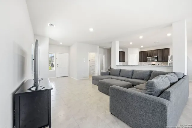 a living room with furniture and kitchen view
