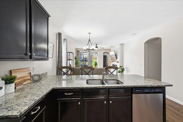 a kitchen with granite countertop a sink stainless steel appliances and cabinets