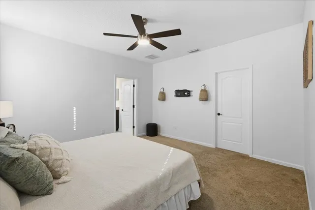 a bedroom with a large bed and a ceiling fan
