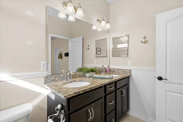 a bathroom with a granite countertop sink a large mirror and a shower