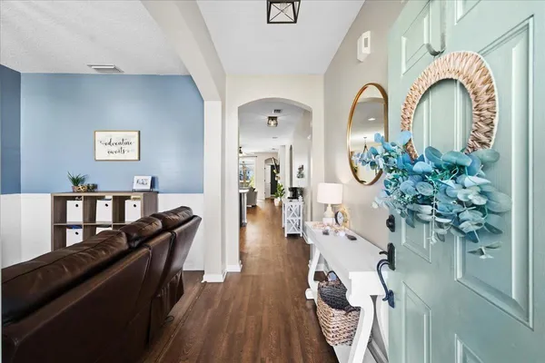 a living room with furniture flowers and wooden floor