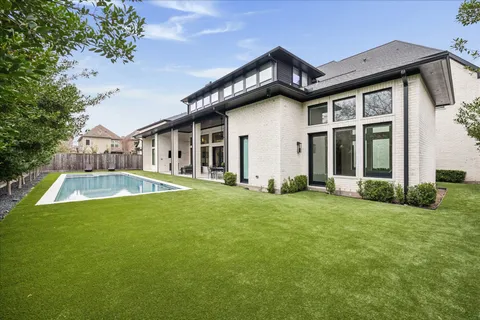 a view of multiple houses with yard and green space