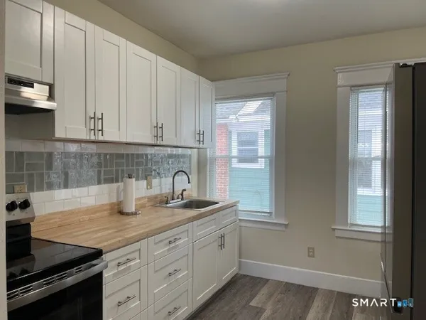 a kitchen with stainless steel appliances granite countertop a sink stove and cabinets