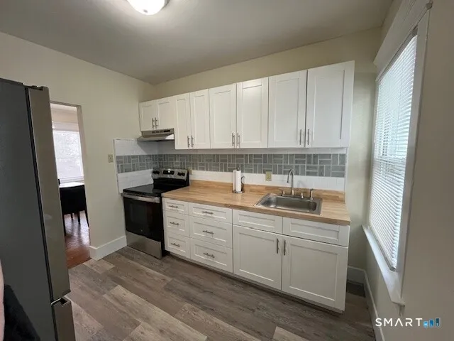 a kitchen with a sink a stove and cabinets