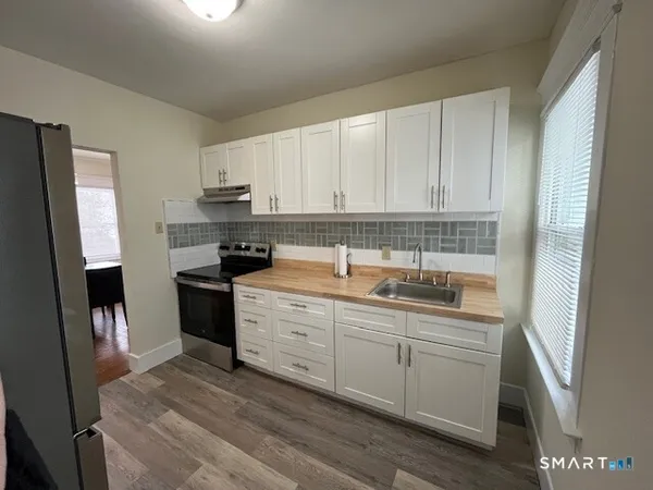 a kitchen with a sink a stove and cabinets