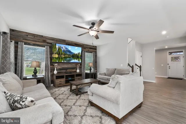 a living room with furniture large window and flat screen tv
