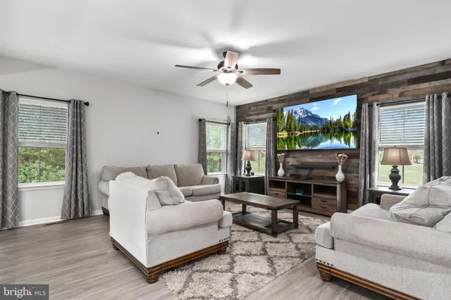a living room with furniture a flat screen tv and a large window