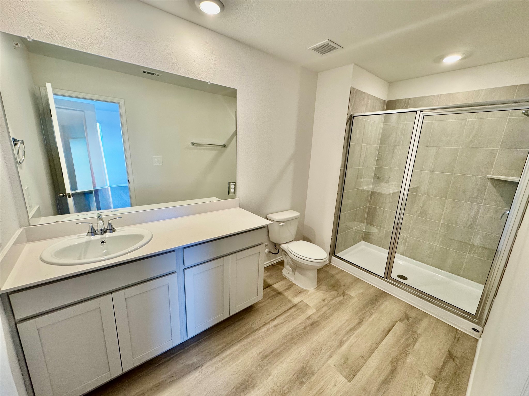 104 Calcite Road, Unit 1 Kyle, TX 78640 - Photo 4 of 7 Full bathroom featuring vanity, a stall shower, light wood-style flooring, and recessed lighting