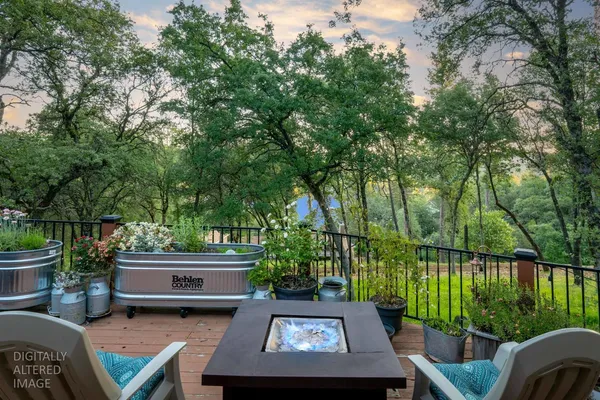 a view of backyard with seating space and trees in the background