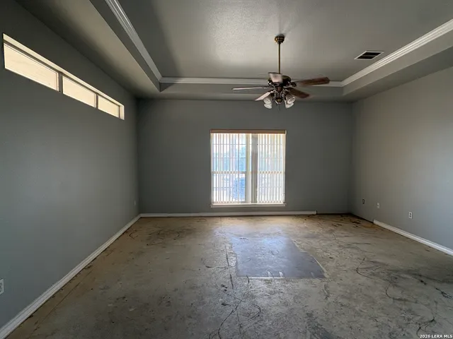 an empty room with windows and fan