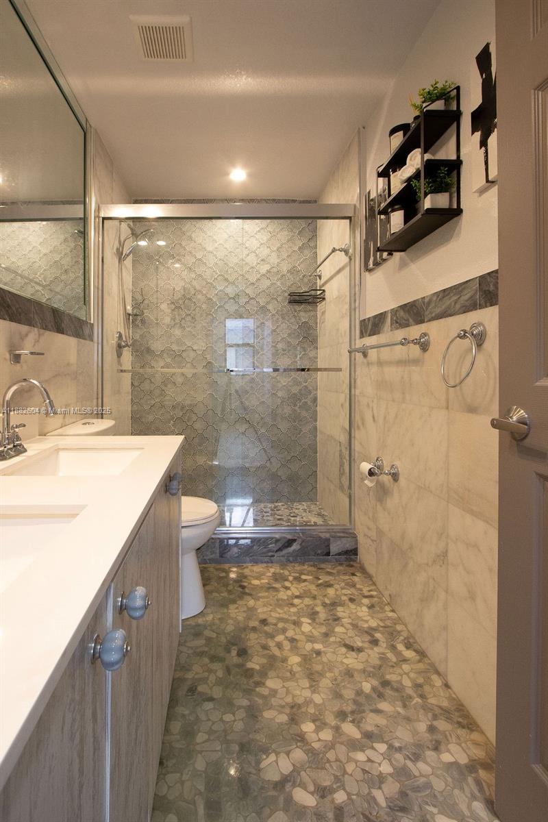 2061 Washington Avenue, Unit 4 Opa-Locka, FL 33054 - Photo 15 of 23 a bathroom with a sink mirror toilet and shower