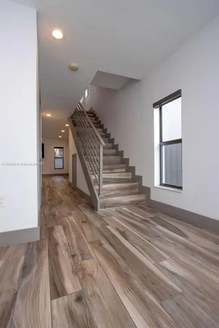 a view of entryway and hall with wooden floor