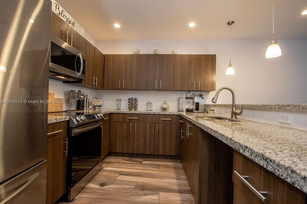 2061 Washington Avenue, Unit 4 Opa-Locka, FL 33054 - Photo 6 of 23 a kitchen with stainless steel appliances granite countertop a sink stove microwave and refrigerator