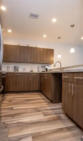 a kitchen with kitchen island granite countertop a sink and cabinets