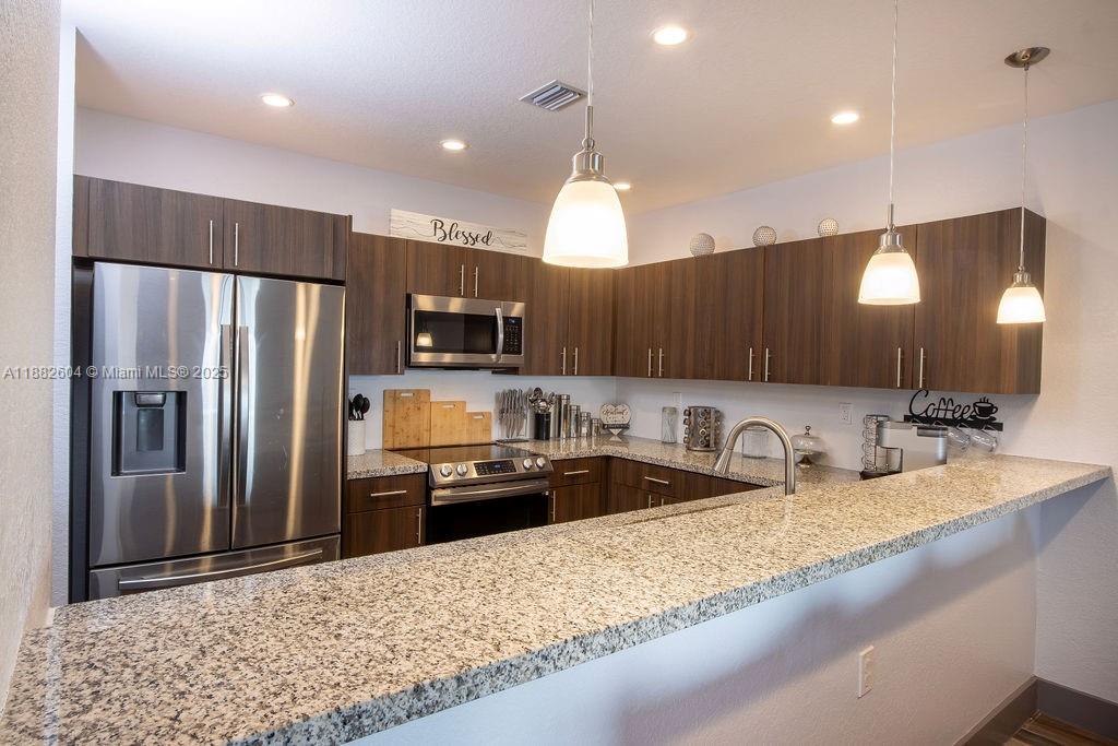 2061 Washington Avenue, Unit 4 Opa-Locka, FL 33054 - Photo 8 of 23 a kitchen with stainless steel appliances granite countertop a sink refrigerator and microwave