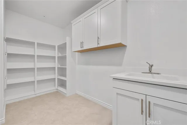 an empty room with chandelier fan and windows