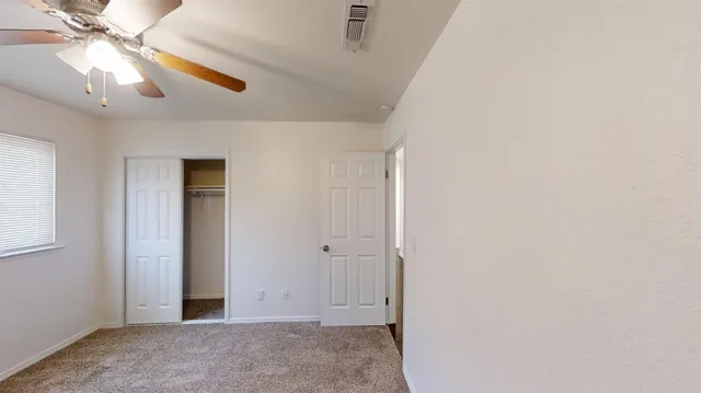 an empty room with closet and fan