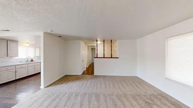 a view of a big room with wooden floor and windows
