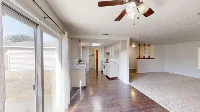 a view of empty room with wooden floor and window