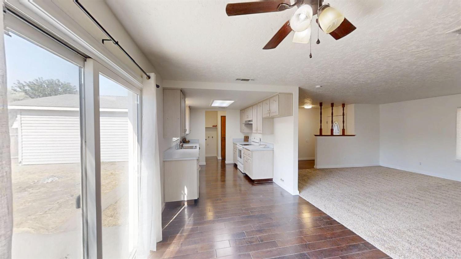 495 Pacific Street Coalinga, CA 93210 - Photo 5 of 33 a view of empty room with wooden floor and window